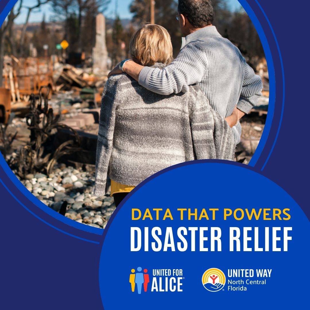 Two people stand with their backs to the camera, looking at the ruins of a house after a natural disaster. The structure is destroyed, with debris scattered around the foundation.